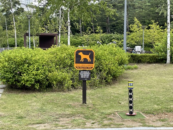 광교호수공원에 설치된 반려견 소변 전용 공중화장실(오른쪽 하단 기둥형태)과 반려견 공중화장실 안내판(사진 중앙)