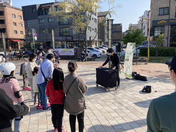 시민들이 ‘거리로 나온 예술’ 프로그램으로 신동카페거리 일원에서 진행된 마술공연 버스킹을 지켜보고 있다.