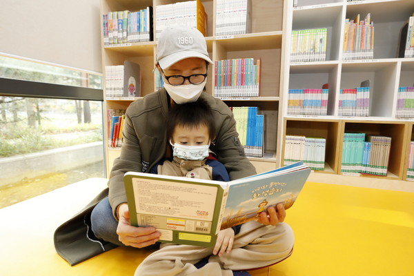 남양도서관 어린이자료실에서 ‘아리와 폴짝이의 화성습지’를 함께 읽는 어린이와 어머니