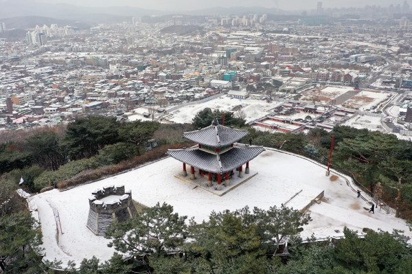 눈이 쌓인 서장대와 서장대에서 볼 수 있는 수원 구도심의 설경.