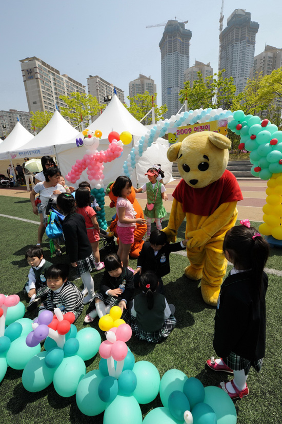 <b>병아리들의 ‘소풍’ 나들이</b> = 화성시 봄사랑 가족 축제 ‘소풍’이 5월1일부터 10일까지 열리고 있는 가운데 4일 동탄 센트럴 파크를 찾은 유치원생들이 캐릭터 인형의 안내에 따라 봉사자와 함께 자신이 만든 풍선 앞에 줄 맞춰 앉고 있다.이 날 어린이들은 서툴지만 재밌게 풍선을 만들어 보는 신나는 체험시간을 가졌다. ⓒ 데일리경인