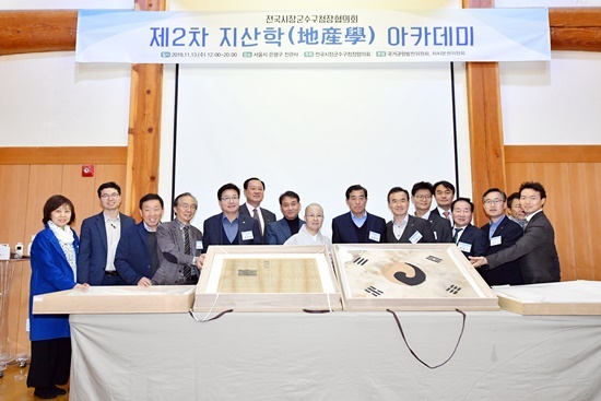 염태영 시장(왼쪽 네 번째)을 비롯한 지산학아카데미 참가자들이 3·1운동 당시에 쓰인 것으로 추정되는 ‘진관사 태극기’ 뒤에서 기념촬영을 하고 있다.