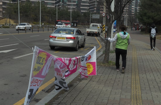 가로수에 설치한 불법현수막을 철거하는 모습.