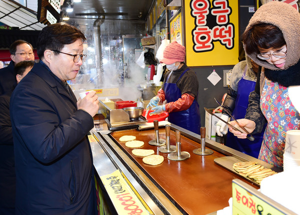 염태영 수원시장이 지역상권을 살리기 위해 못골시장에서 직접 장을 보며 간식거리를 구매하고 있다.
