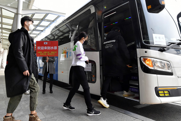 입국한 유학생들이 인천공항 버스정류소에서 수원시가 운영하는 버스에 타고 있다.