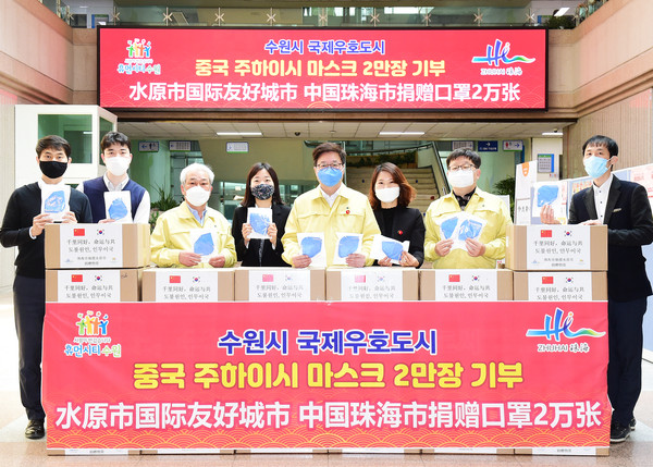 염태영 시장과 수원시 공직자들이 주하이시에서 보낸 마스크 상자를 앞에 두고 기념촬영을 하고 있다.