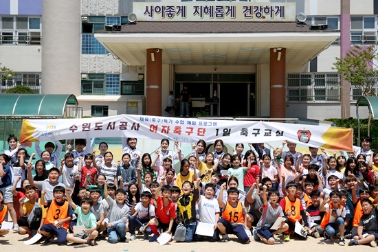 지난해 5월 수원시 구운초등학교에서 열린 수원도시공사 여자축구단 일일체육교사 행사에서 선수단과 학생들이 기념촬영을 하고 있다.