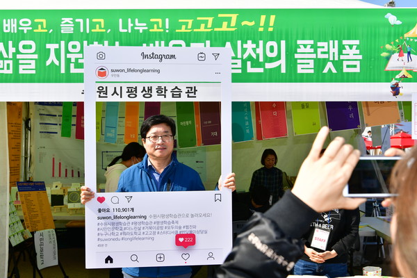 수원시 평생학습축제에 참여한 평생학습관 부스에서 염태영 수원시장이 시민들에게 참여를 독려하는 홍보사진을 찍고 있다.