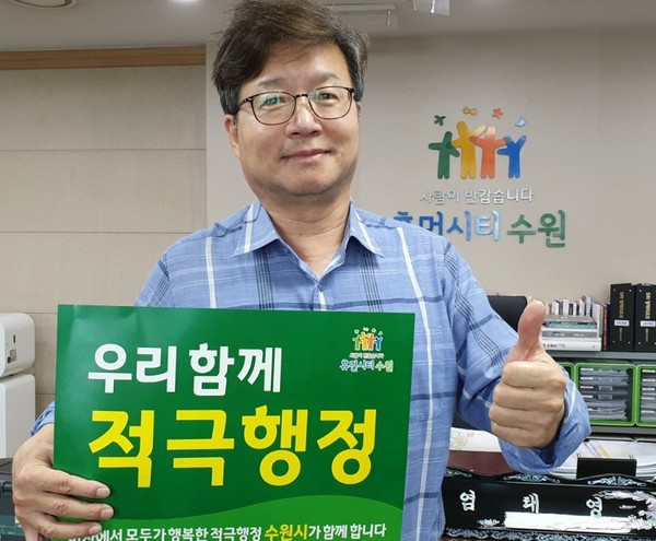 염태영 시장이 적극행정 실천을 다짐하는 문구(우리 함께 적극행정)가 적힌 피켓을 들고 기념촬영을 하고 있다.