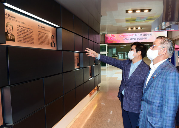 염태영 시장이 최신원 회장에게 수원시청 본관로비에 설치된 ‘명예의 전당’에서 최종건·최종현 전 회장의 사진과 간략한 생애·경력·업적 등이 새겨진 동판을 안내하고 있다.