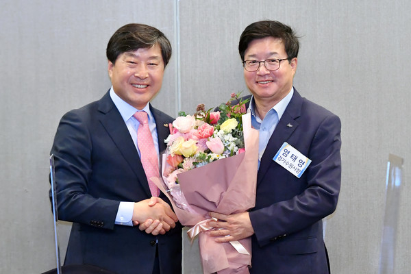 전임 회장인 황명선 논산시장이 염태영 시장에게 꽃다발을 전달하고 있다.