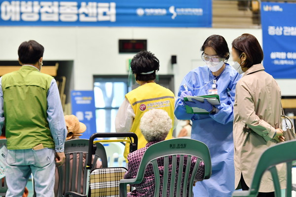 간호사가 백신을 맞은 어르신의 상태를 확인하고 있다.