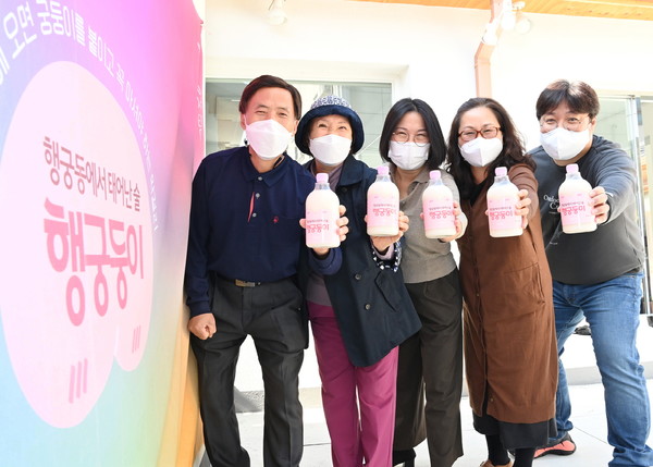 행궁동 주민들로 구성된 수원양조협동조합 황현노 조합장과 조합원들이 행궁둥이 막걸리를 들어보이고 있다.