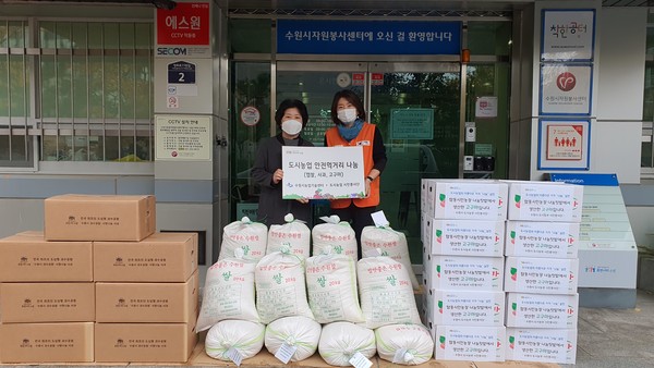 박현자 수원시 농업기술과장(왼쪽)이 수원시자원봉사센터 관계자에게 농산물을 전달하고 있다.
