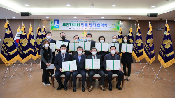 지난 18일 수원시 장안구에서 주민자치회의 성공적인 확대를 위한 멘토-멘티 협약식이 열린 가운데 주민자치회장들이 협약서를 들고 있다.