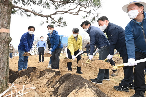 유문종 제2부시장(왼쪽 3번째) 등 참석자들이 삽으로 흙을 퍼 나무 뿌리를 덮고 있다.