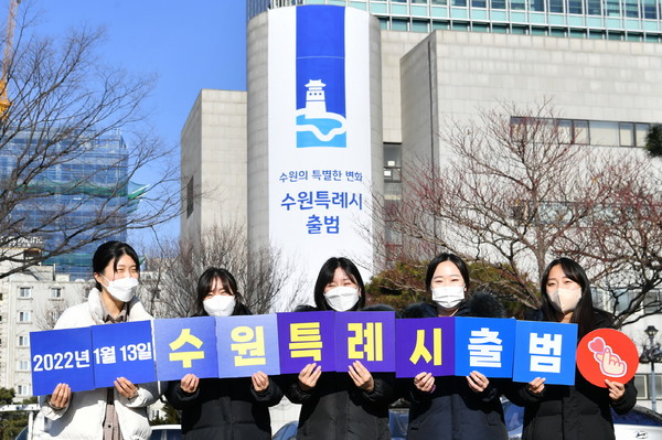 수원특례시 출범을 기념해 수원시 공무원들이 피켓을 들고 사진을 촬영하고 있다.