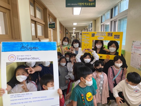 수원시 관계자들이 어린이날을 맞아 보육·아동시설을 격려하기 위해 방문한 다함께돌봄센터에서 어린이들과 기념촬영을 하고 있다