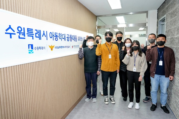 수원특례시 아동학대 공동대응센터에 소속된 실무자들이 센터 앞에서 파이팅을 외치며 기념촬영을 하고 있다.