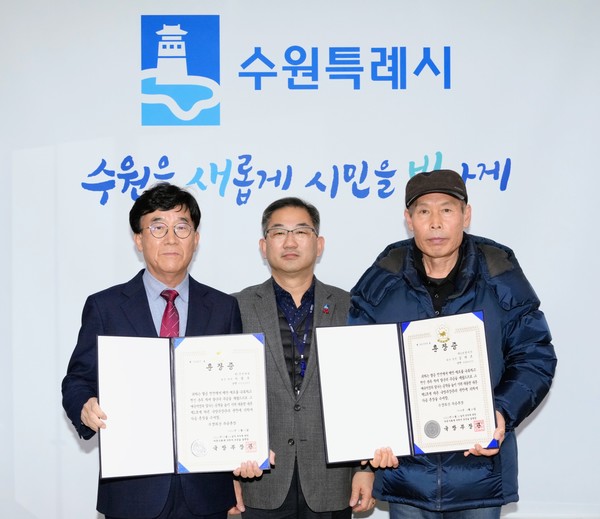 홍건표 수원시 복지여성국장(가운데)이 화랑무공훈장을 전수받은 유족들과 함께하고 있다.