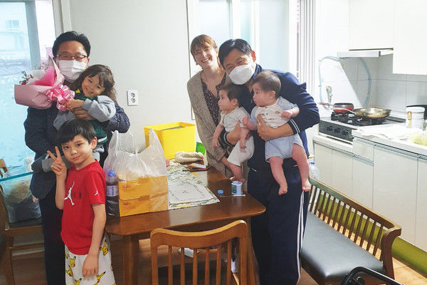 임시주거시설에 입주한 최민웅씨 자녀의 유치원 수료를 기념해 조원1동 주민단체가 마련한 꽃다발과 통닭 등 깜짝 선물을 전달하고 있다.