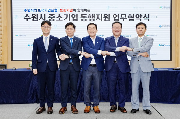 지난 7월 ‘수원시 중소기업 동행지원 업무협약식’에서 이재준 시장과 금융기관 및 보증기관 관계자들이 맞손을 잡고 있다.