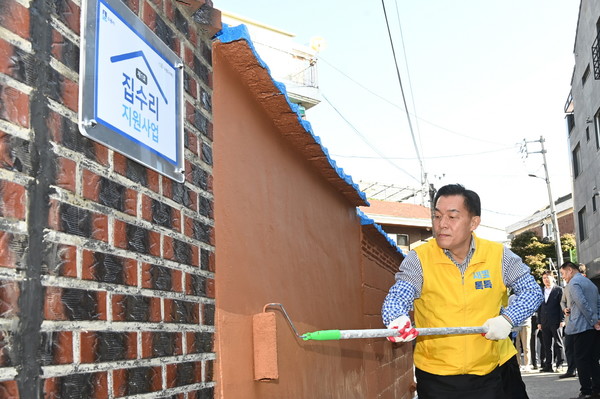 이재준 시장이 저층 주거지 집수리 사업 1호 대상지에서 담장 보수를 하고 있다.