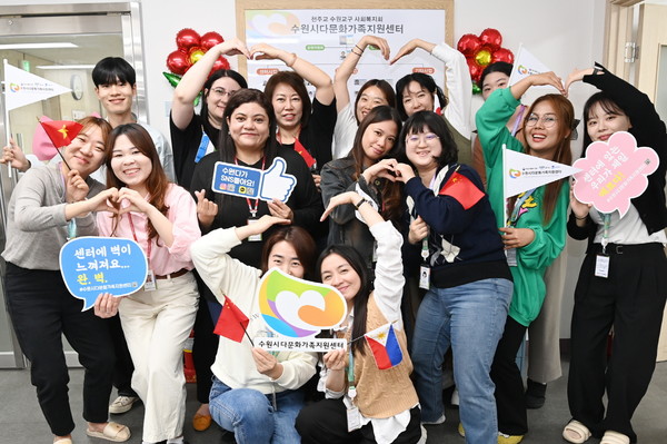 수원시다문화가족지원센터에서 다양한 국적의 직원과 봉사자들이 기념촬영을 하고 있다.