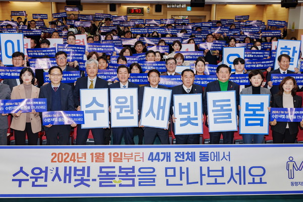 지난해 12월 수원시 관계자들이 수원새빛돌봄 전체 동 확대를 홍보하는 손팻말을 들어 보이고 있다.
